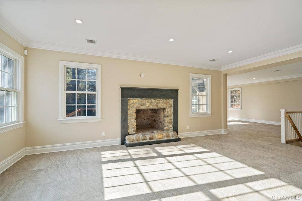 89 Mill River Road, Upper Brookville, NY 11771 Unfurnished living room featuring ornamental molding, a fireplace, and recessed lighting