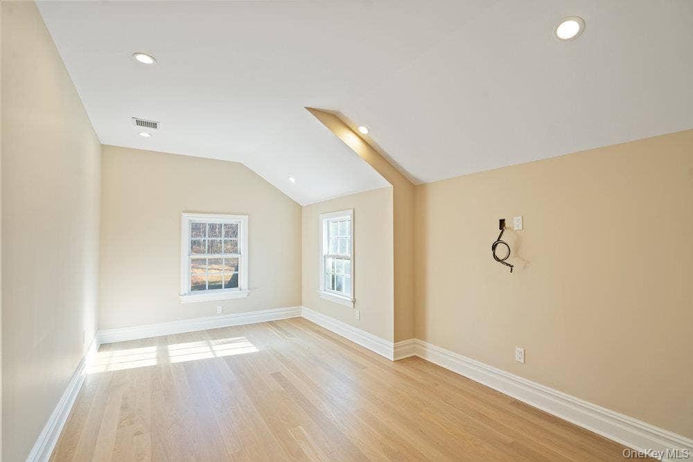 89 Mill River Road, Upper Brookville, NY 11771 Spare room with vaulted ceiling, light wood-style floors, and recessed lighting