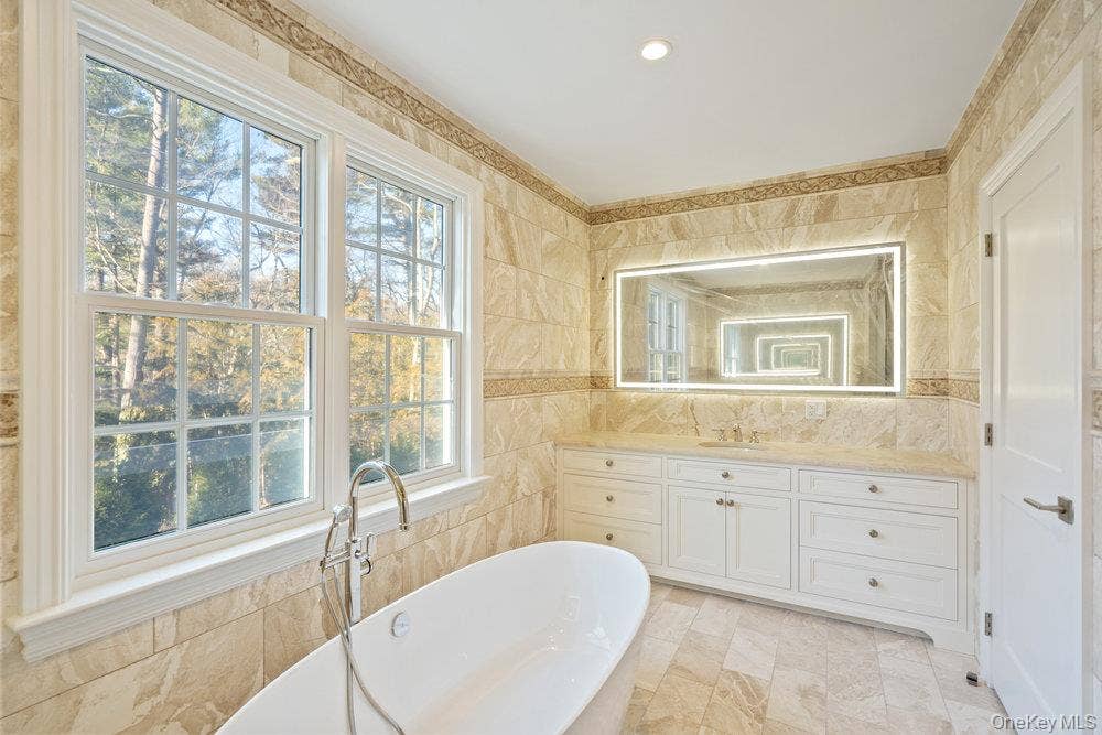 89 Mill River Road, Upper Brookville, NY 11771 Bathroom featuring vanity, tile walls, and a freestanding bath