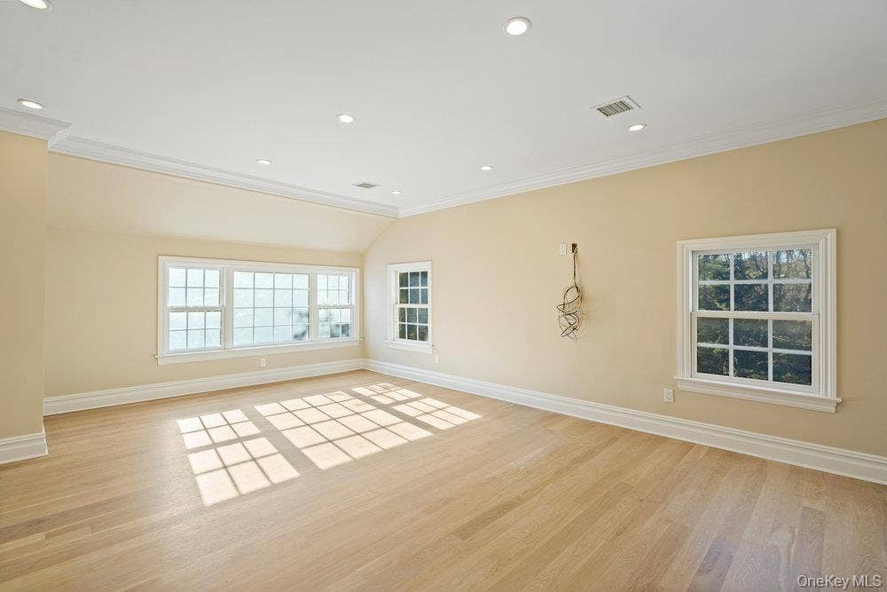 89 Mill River Road, Upper Brookville, NY 11771 Empty room with light wood finished floors, ornamental molding, and recessed lighting