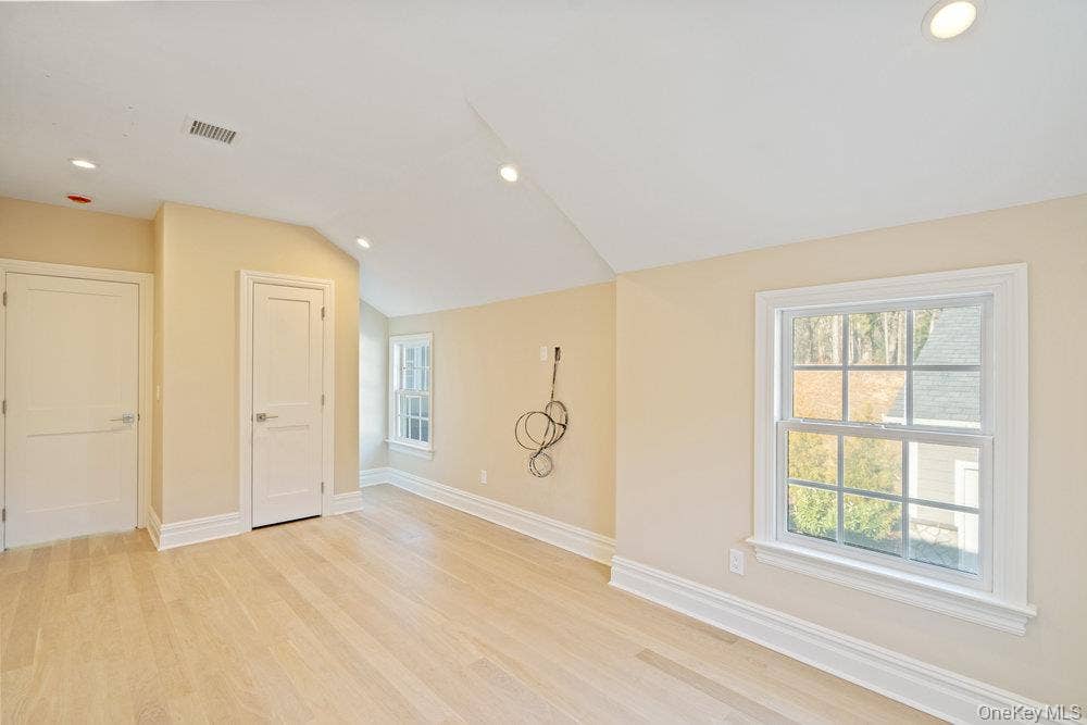 89 Mill River Road, Upper Brookville, NY 11771 Unfurnished room featuring recessed lighting, light wood-style flooring, and vaulted ceiling