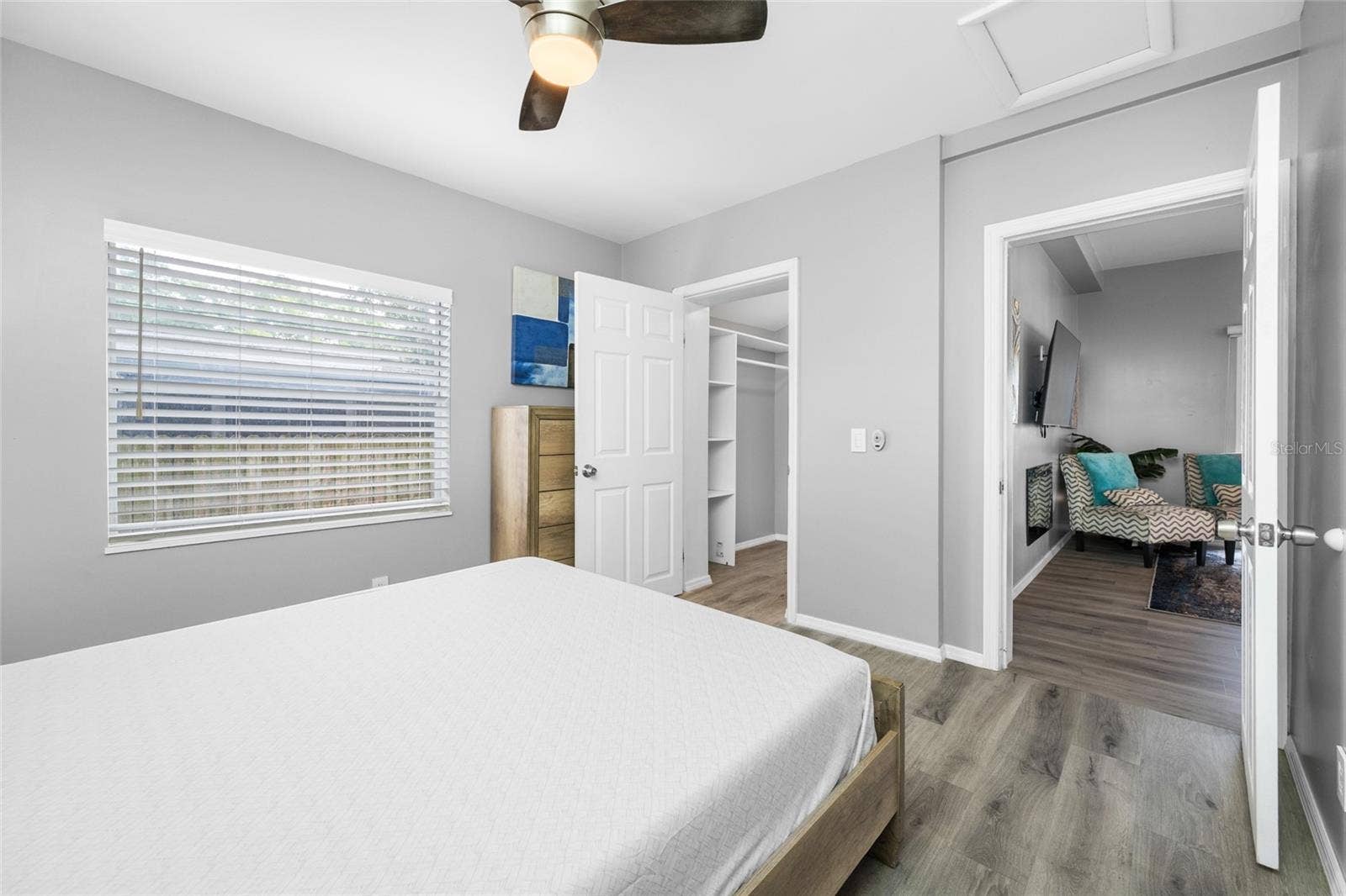 5044 BETTY STREET N, St Petersburg, FL 33709 Primary Bedroom suite with walk-in closet, with built in shevles, that opens through to private en-suite updated bathroom with marble tile and glass shower.