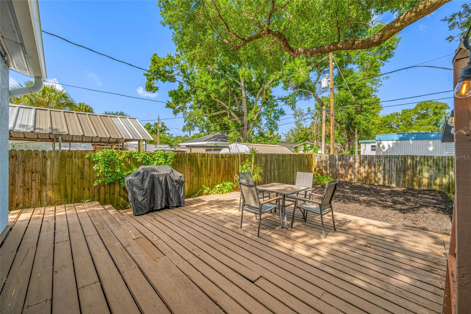 5044 BETTY STREET N, St Petersburg, FL 33709 Fenced in back yard with 20ft wide deck that leads to detached workshop and shed.