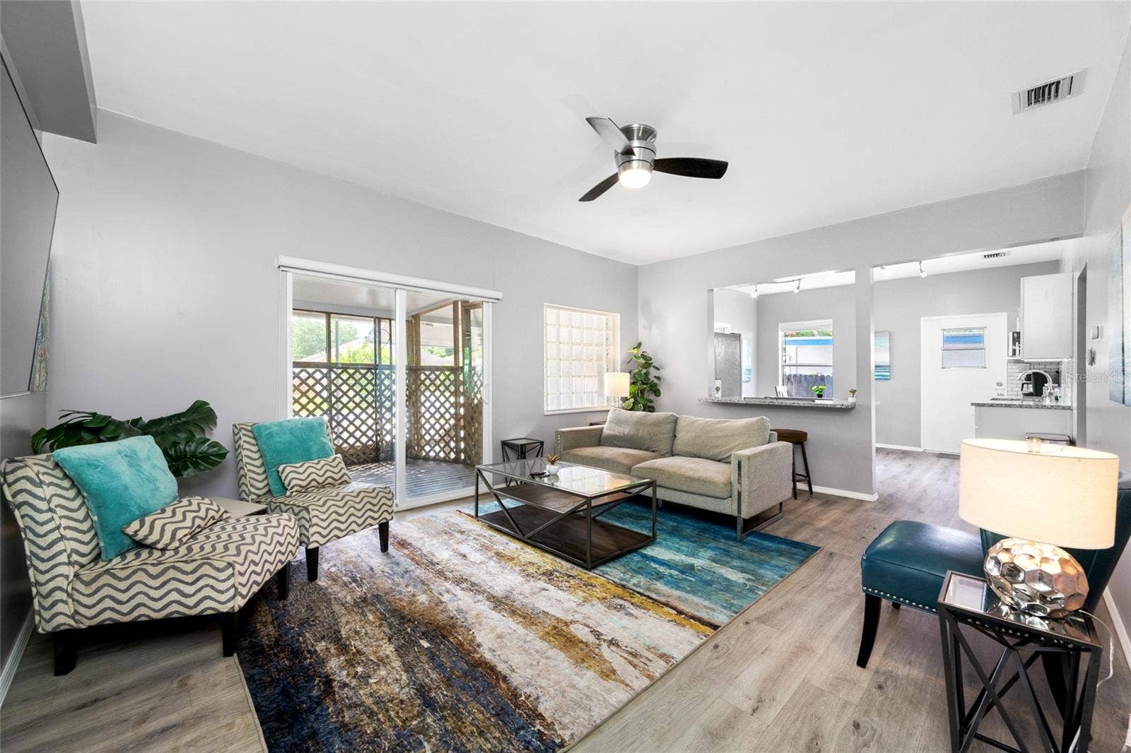 5044 BETTY STREET N, St Petersburg, FL 33709 Living Room with electric fireplace and sliding door to the front screened porch