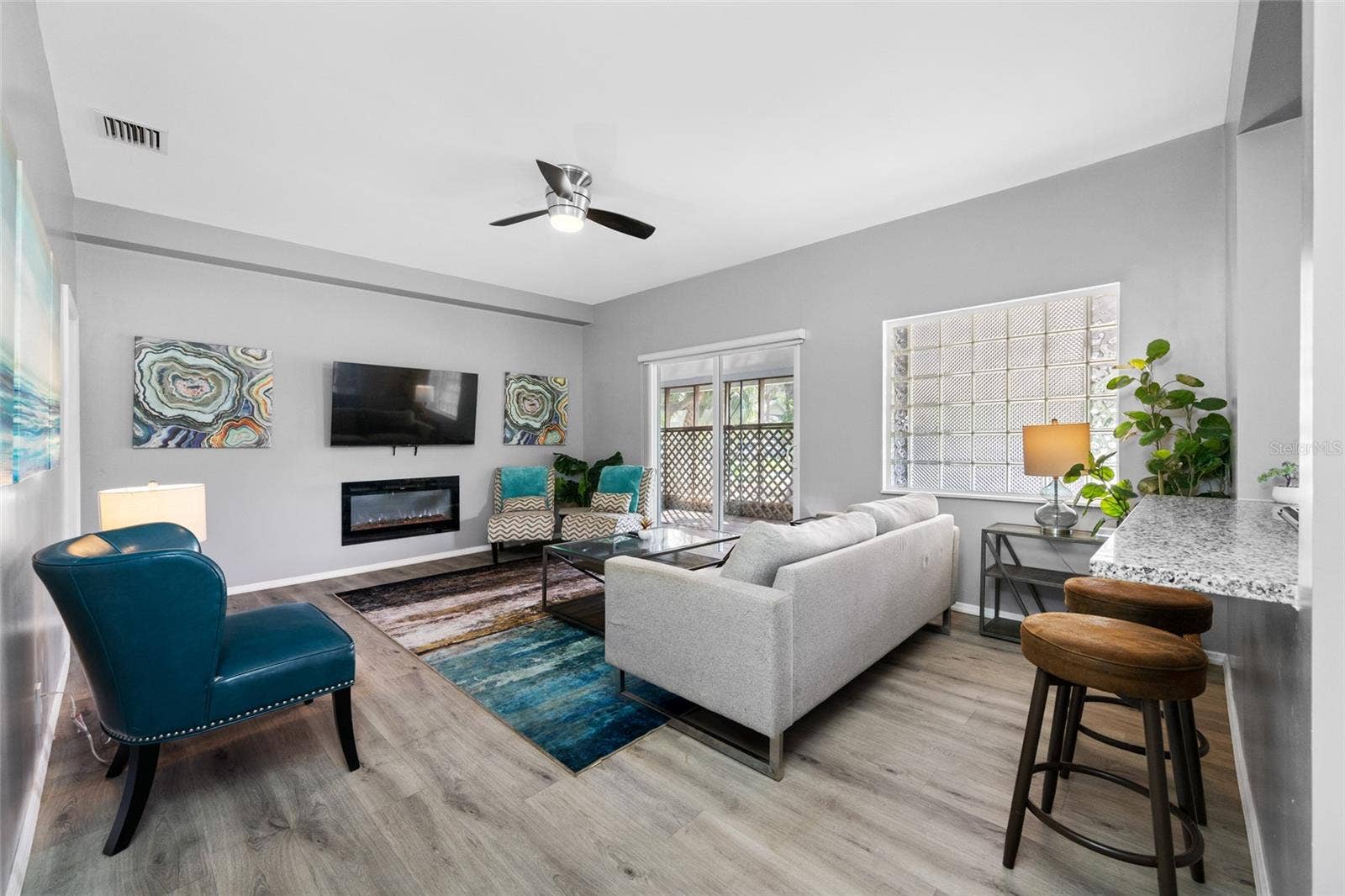 5044 BETTY STREET N, St Petersburg, FL 33709 Living Room with electric fireplace and sliding door to the front screened porch