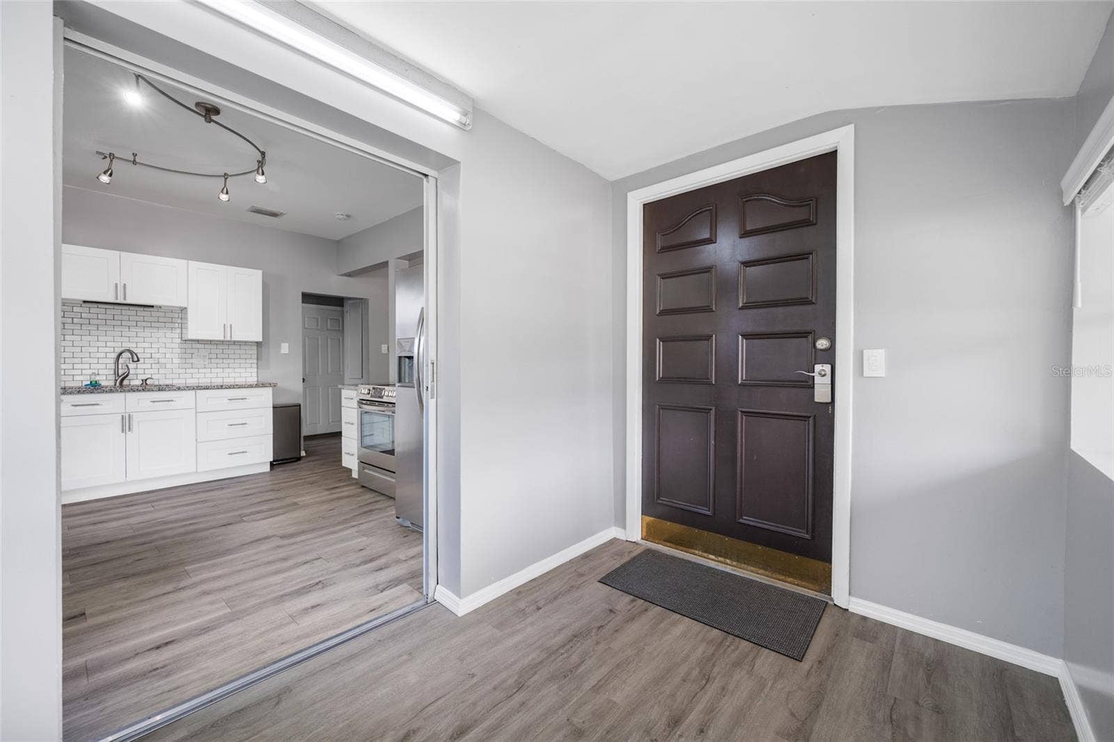 5044 BETTY STREET N, St Petersburg, FL 33709 Front door opens into Foyer / mudroom with W/D, large shelf, and has a pocket door to keep noise down.