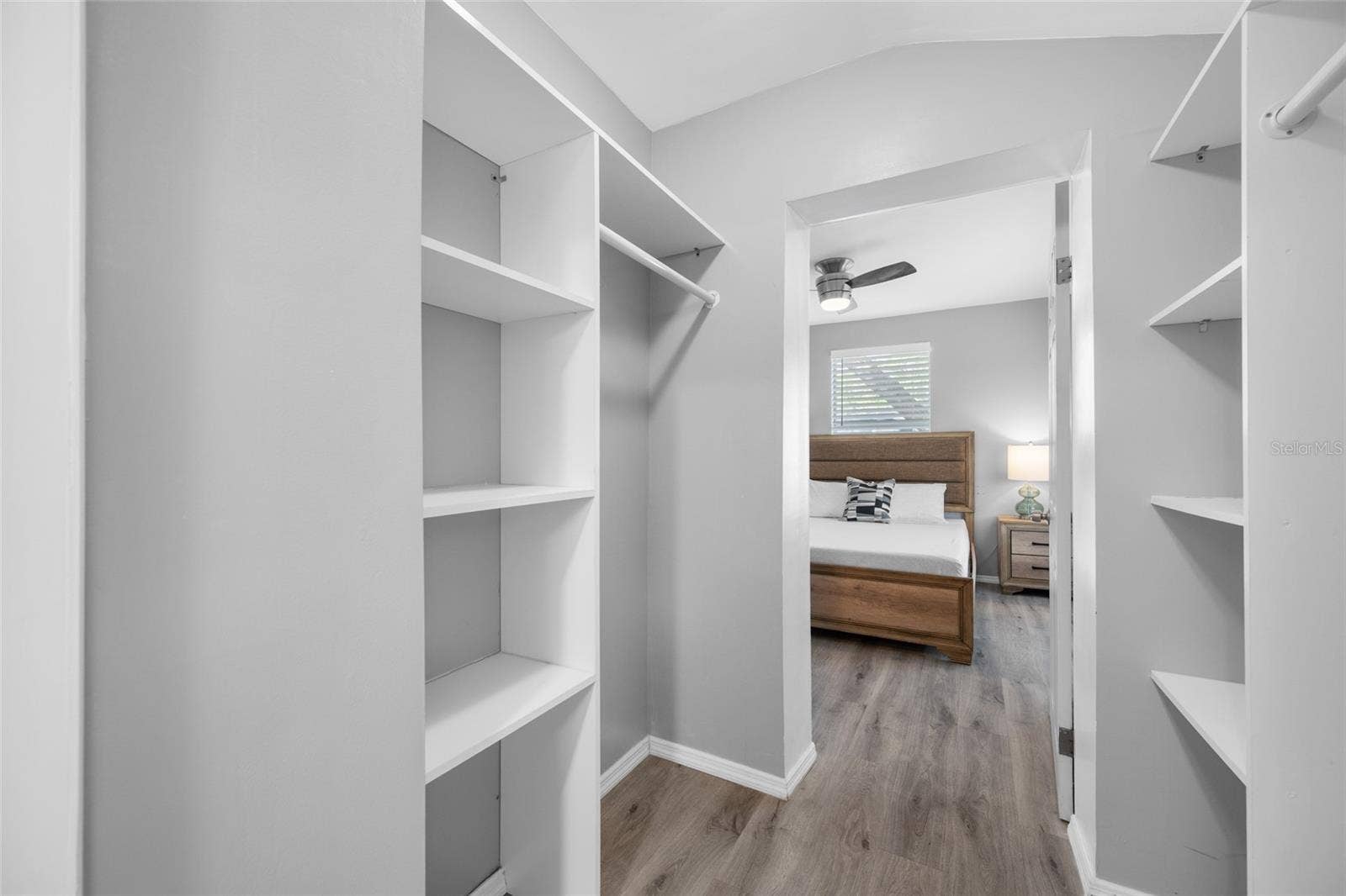 5044 BETTY STREET N, St Petersburg, FL 33709 Primary Bedroom suite with walk-in closet, with built in shevles, that opens through to private en-suite updated bathroom with marble tile and glass shower.