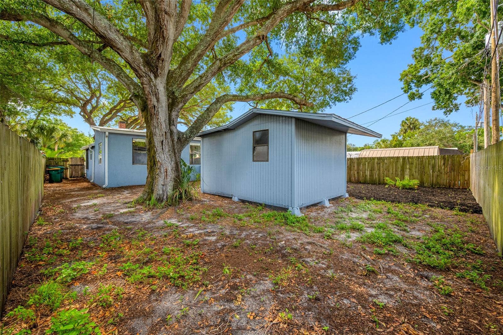 5044 BETTY STREET N, St Petersburg, FL 33709 Fenced in back yard with 20ft wide deck that leads to detached workshop and shed.