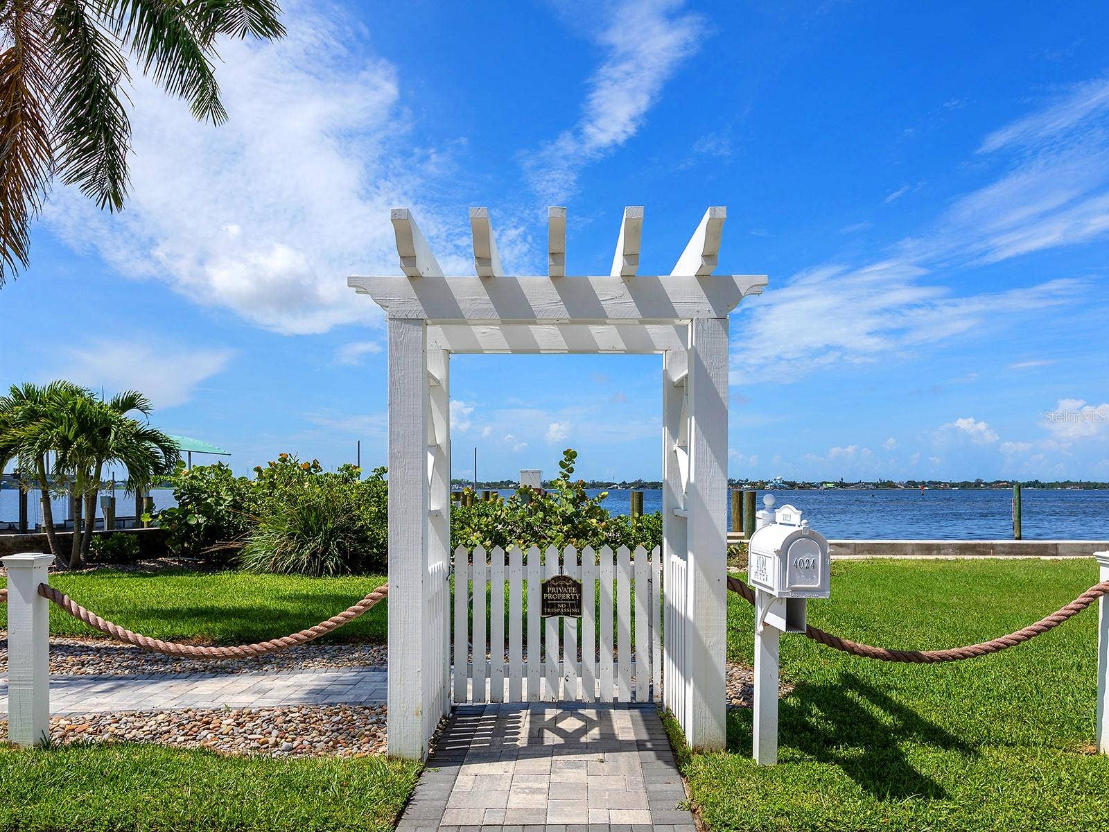 4024 11TH STREET COURT W, Palmetto, FL 34221 Arbor across the road from the home brings you to your paver terrace and a new 38-foot deeded dock with a covered boat lift beside a a brand-new, elevated seawall