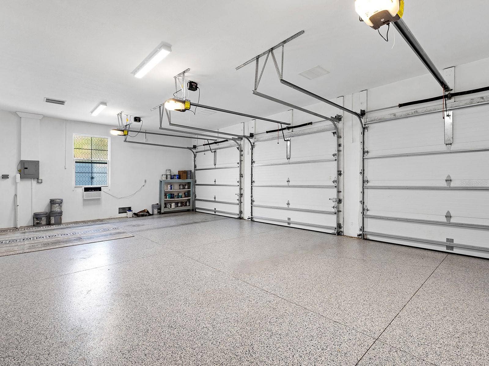 4024 11TH STREET COURT W, Palmetto, FL 34221 Oversized multi-car garage with epoxy flooring, high clearance for equipment, and built-in storage potential