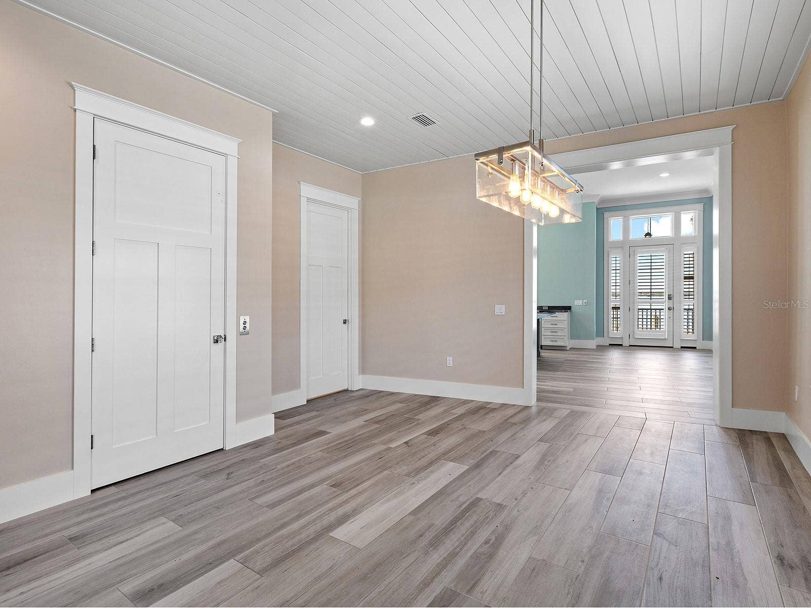 4024 11TH STREET COURT W, Palmetto, FL 34221 Ground-floor dining area between the pool deck and front door featuring elevator access, a half bath, and seamless flow to the laundry room and primary suite with two closets