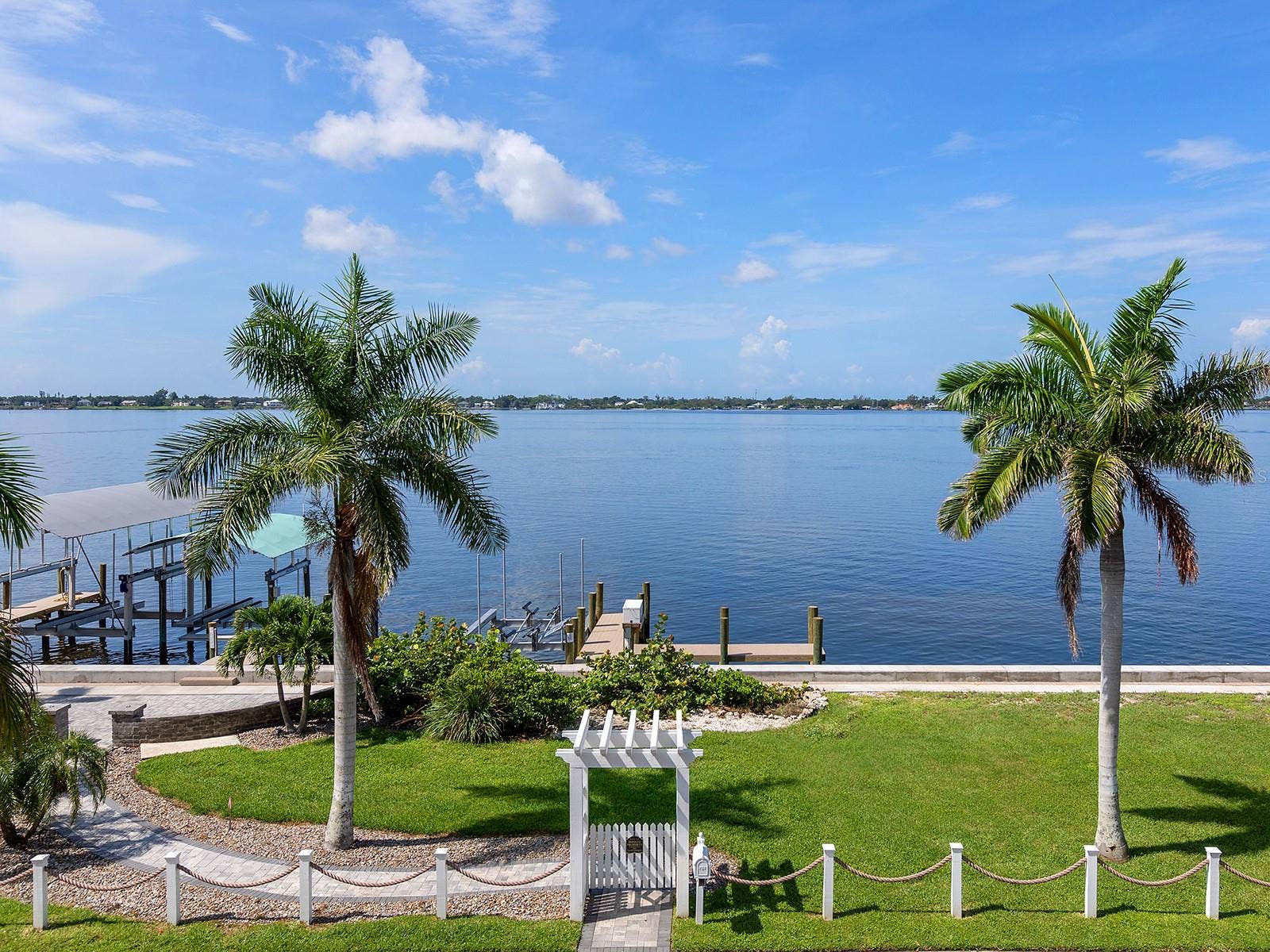 4024 11TH STREET COURT W, Palmetto, FL 34221 Sweeping view from the covered primary suite balcony overlooking the private dock on the Manatee Rivera front-row seat to passing coastal wildlife, gentle water breezes, and tranquil riverfront vistas
