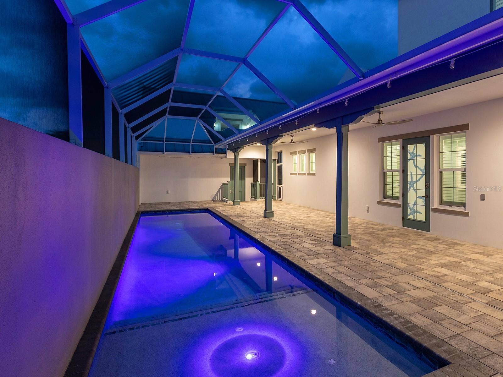 4024 11TH STREET COURT W, Palmetto, FL 34221 38-foot heated saltwater pool with self-cleaning system, app-controlled lighting, and direct deck access to the ground-floor primary suite