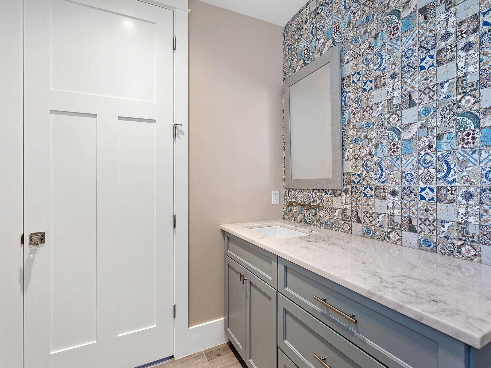 4024 11TH STREET COURT W, Palmetto, FL 34221 Half bath on the ground floor. Mediterranean-inspired mosaic tile feature wall, brushed gold wall-mounted hardware, and light quartz countertops