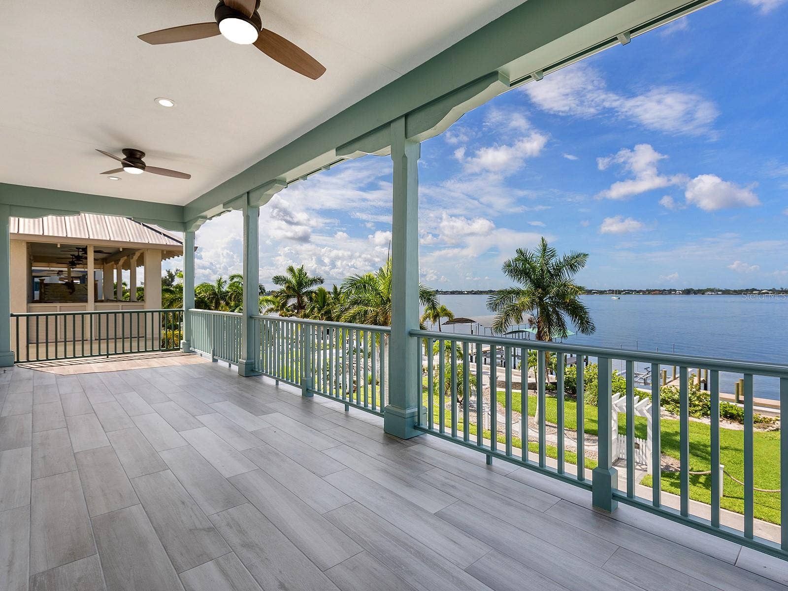 4024 11TH STREET COURT W, Palmetto, FL 34221 Expansive covered balcony offering sweeping water views, ceiling fans, and tiled flooring designed for outdoor living