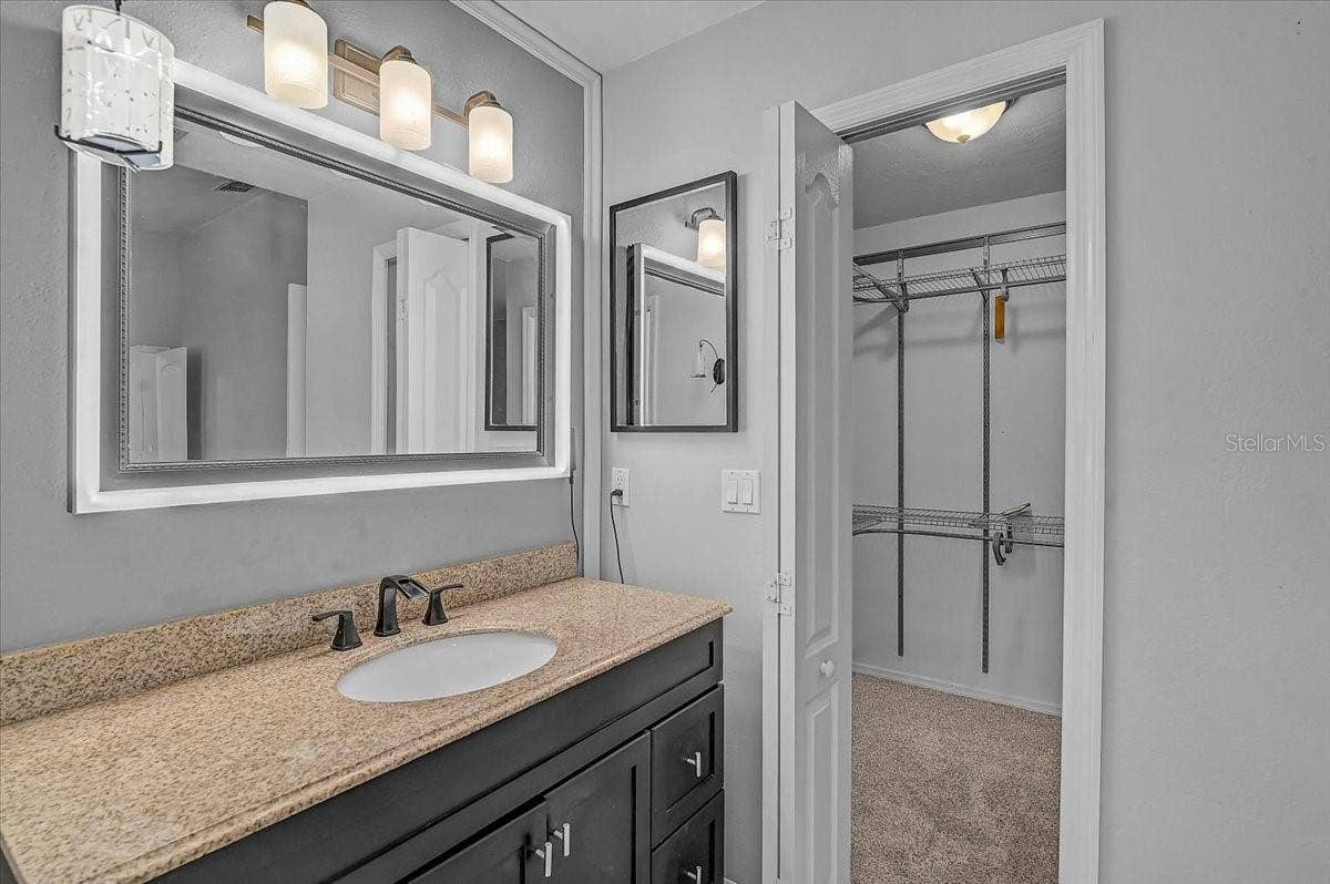 7739 33RD LANE E, Sarasota, FL 34243 Smart mirror custom color light frame in primary bathroom and Walkin Closet.