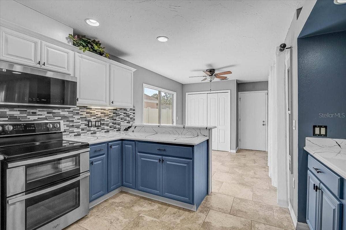 7739 33RD LANE E, Sarasota, FL 34243 Kitchen Looking into Dinette and Sliding Glass Doors to Side Patio,