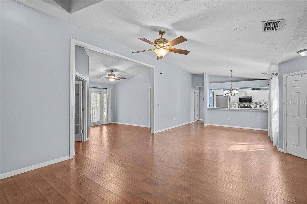 7739 33RD LANE E, Sarasota, FL 34243 Living Room, Dining Room, Kitchen, Den with Double French Doors, Open Bonus Room to Exterior French Doors to Back Patio and Pond.