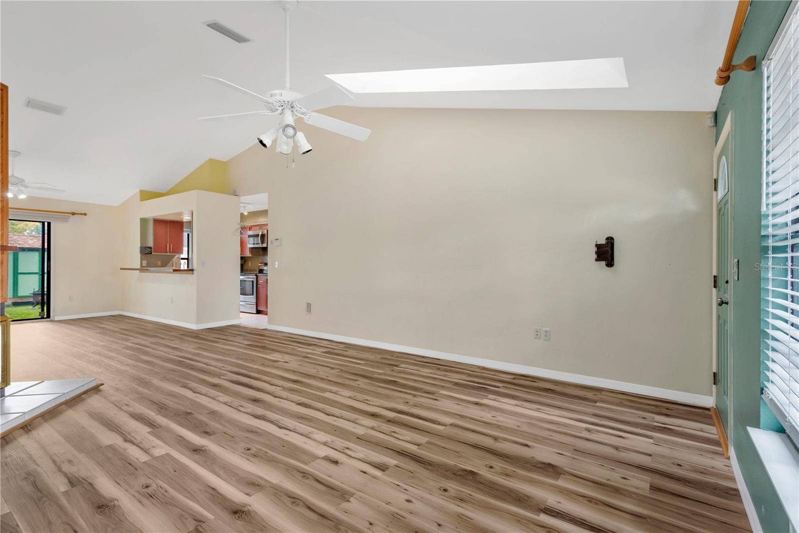 5546 34TH COURT E, Bradenton, FL 34203 Living Room with skylights, ceiling fan and lofted ceilings.