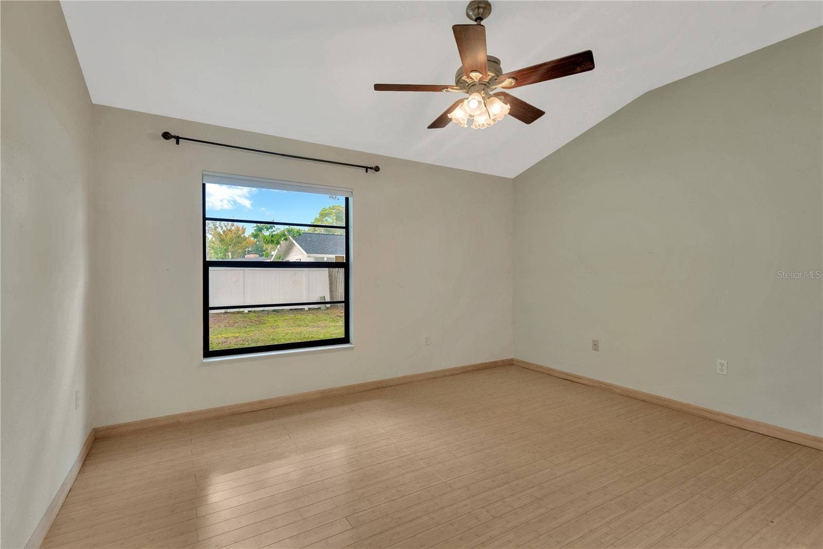 5546 34TH COURT E, Bradenton, FL 34203 Primary Bedroom with lofted ceiling and ceiling fan, overlooking the private backyard
