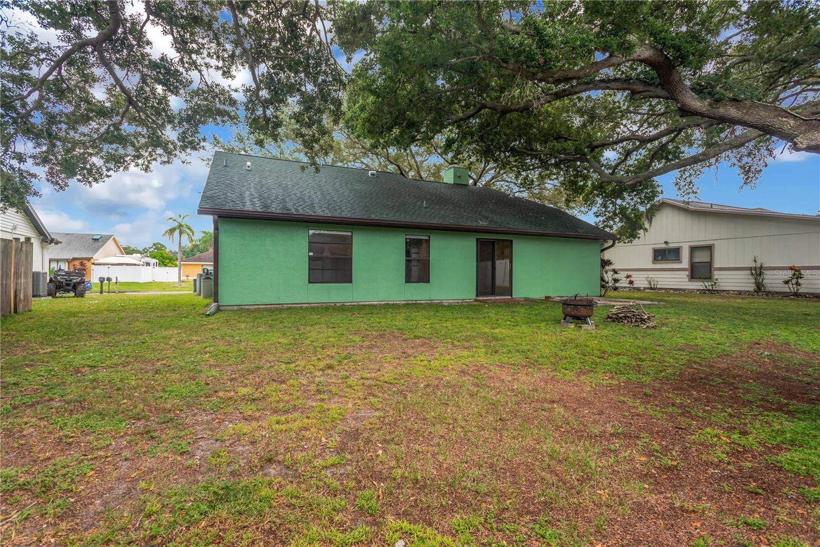 5546 34TH COURT E, Bradenton, FL 34203 Backyard with firepit and wood, ready for those cool Fall and Winter evenings