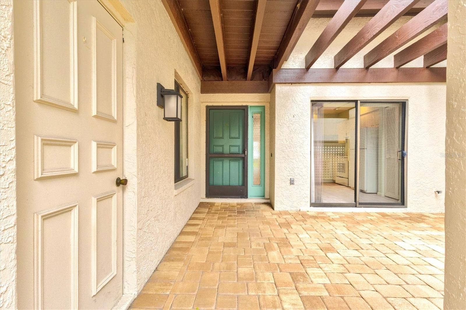 3118 WINDRUSH BOURNE, #8, Sarasota, FL 34235 Garage door to the left, showing covered walkway to the front door
