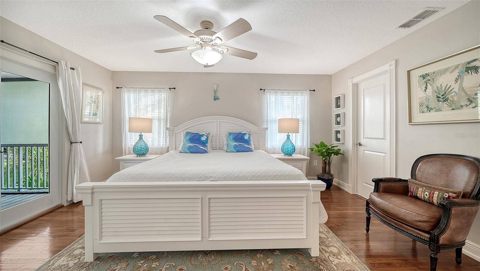 Spacious primary suite with hardwood floors and private balcony access.