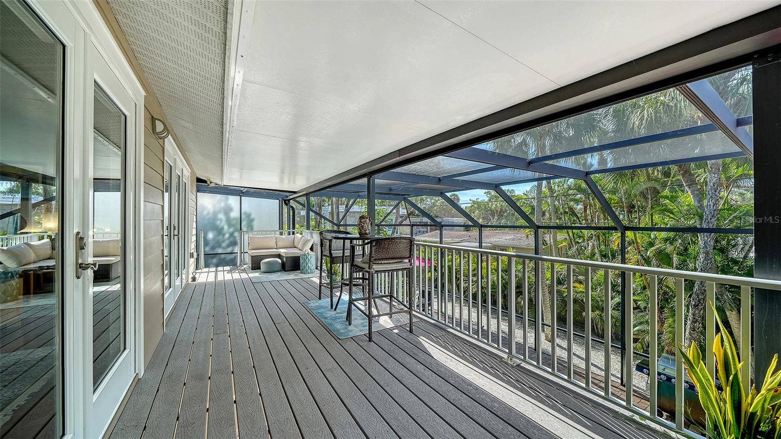 Covered screened balcony overlooking the tropical surroundings.