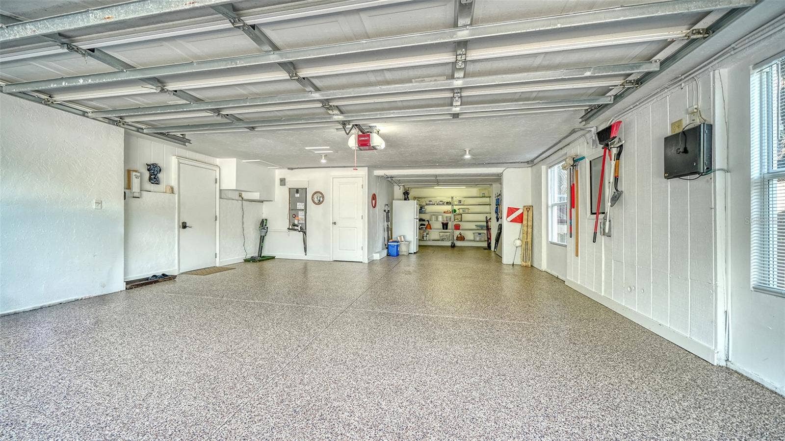 Oversized two-car garage with resurfaced and sealed floor and additional storage.