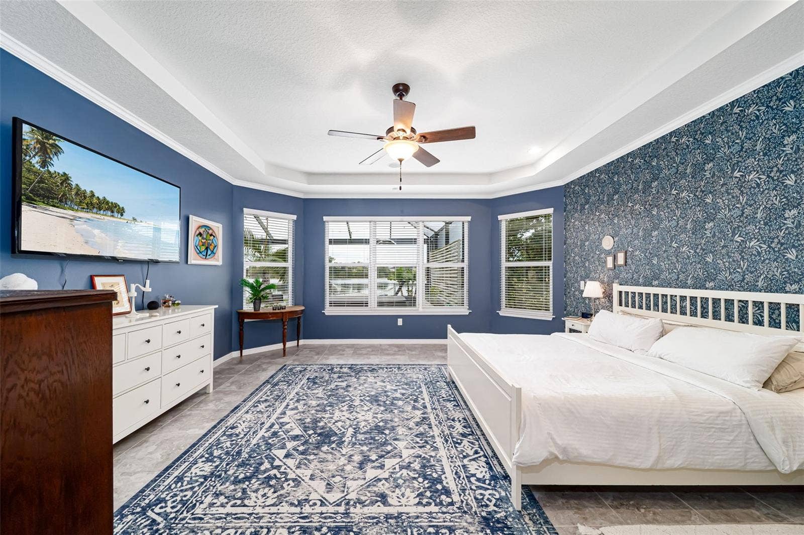 Primary bedroom with beautiful views and elegant designer wallpaper.