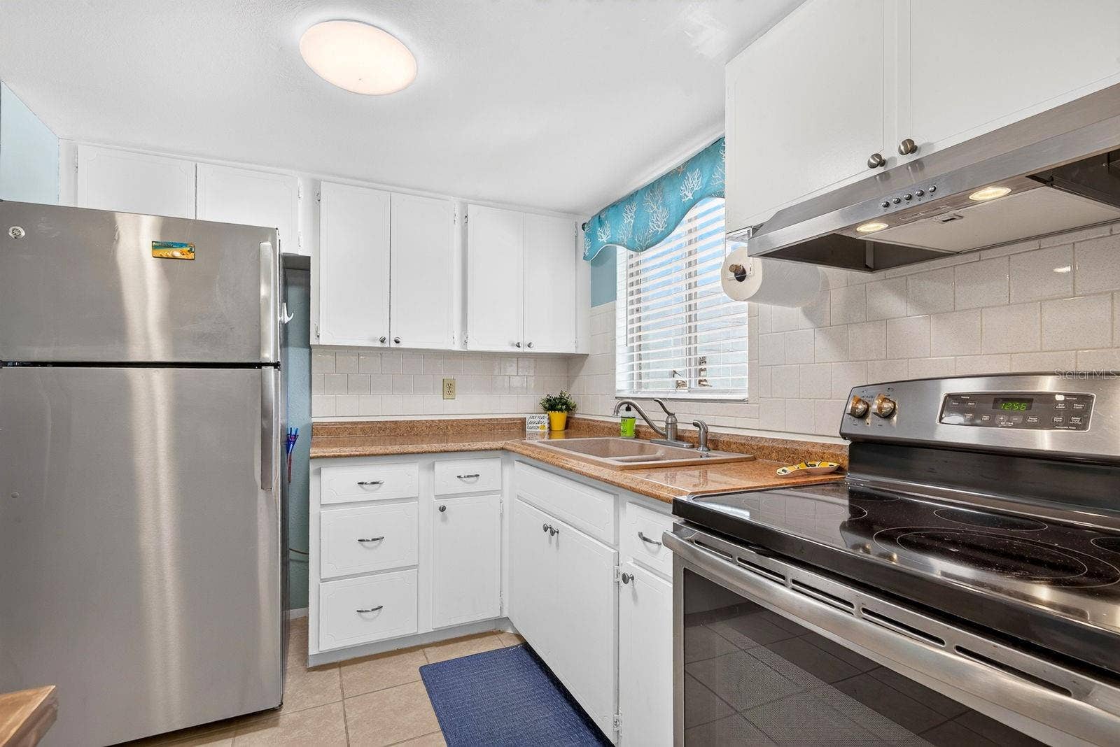 Kitchen with updated appliances and white tile back splash