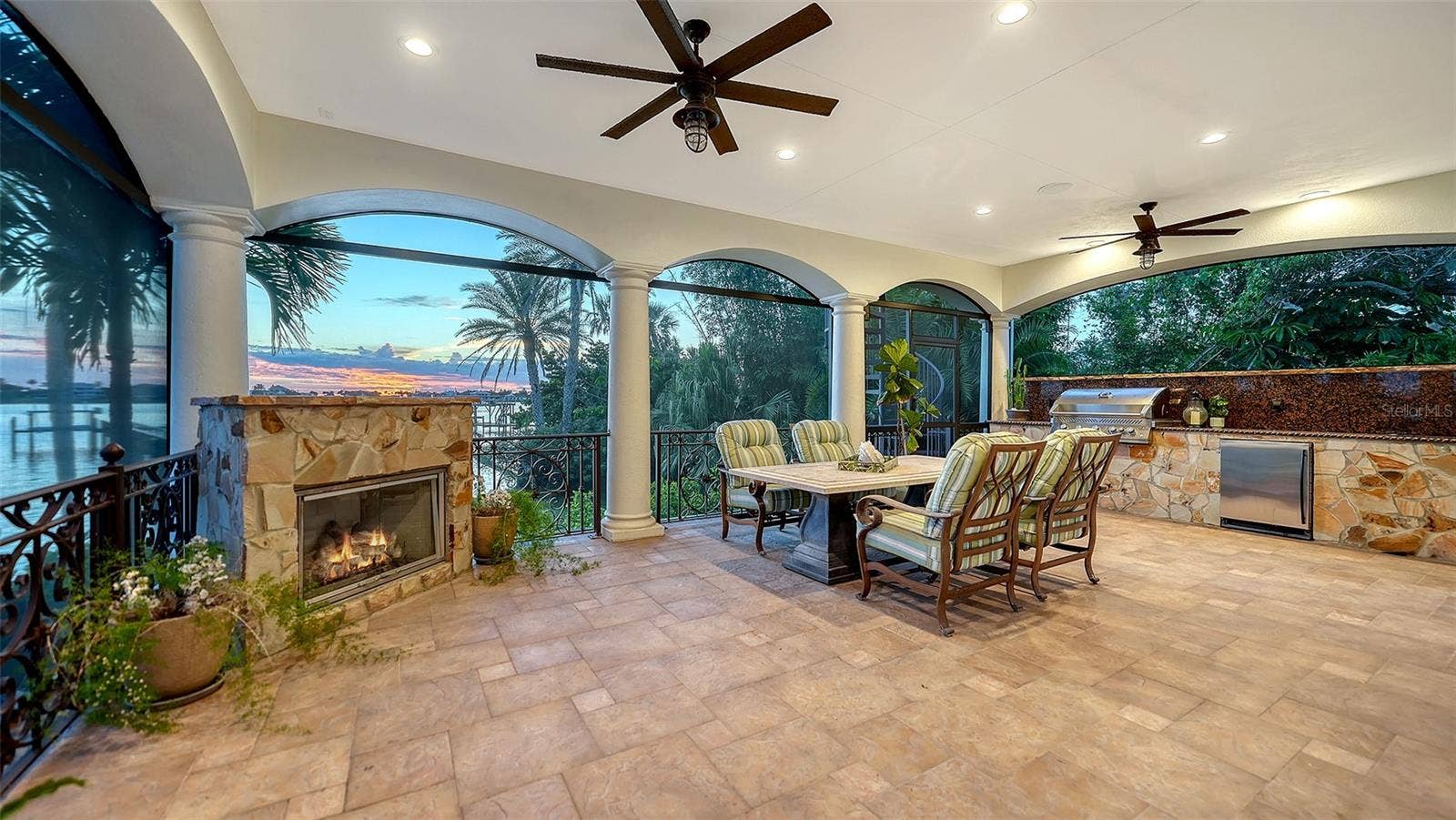 2115 LYCHEE LANE, Nokomis, FL 34275 Outdoor living off the family room, with screening so no bugs allowed in while dining or relaxing by the gas fireplace
