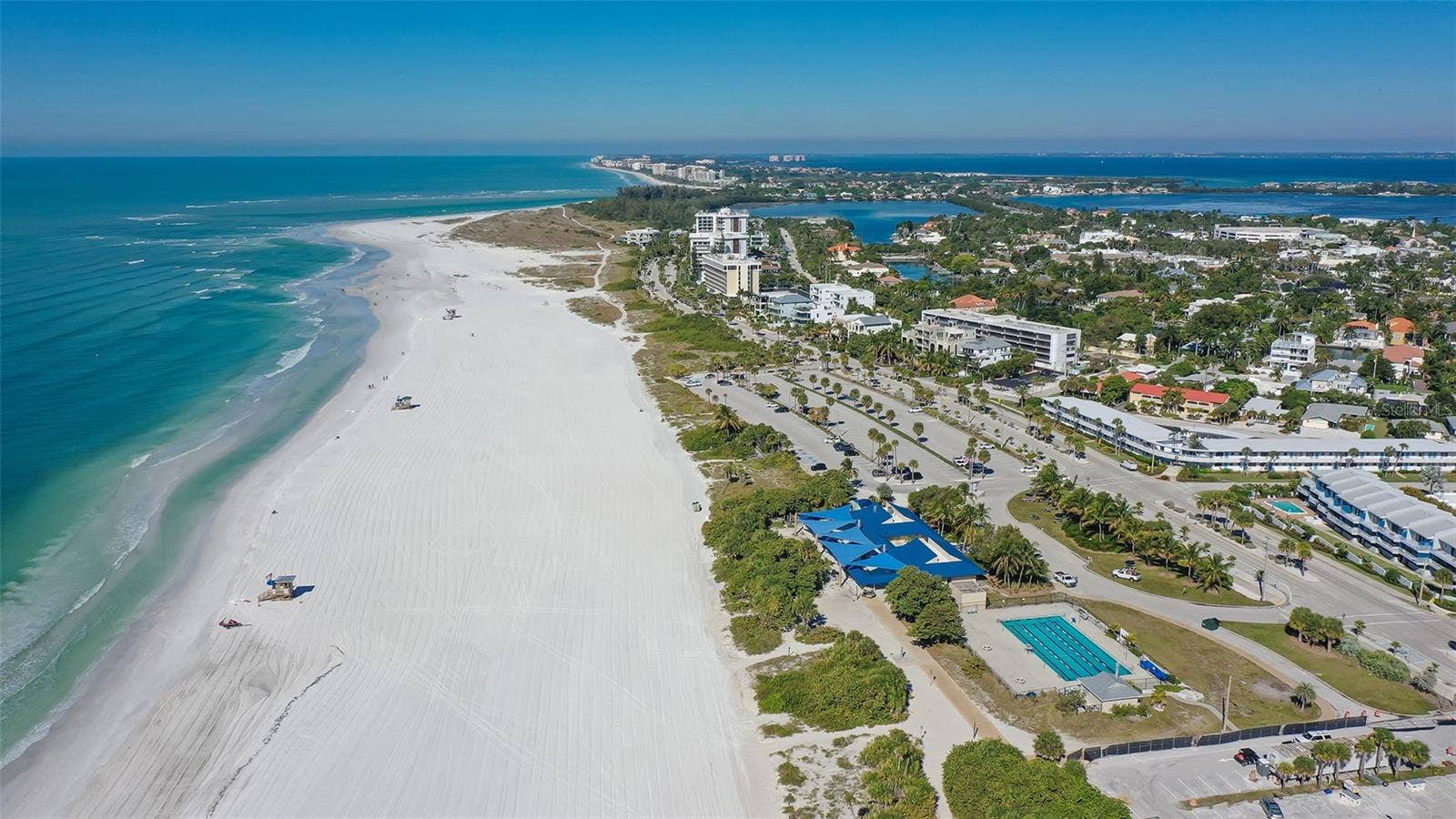 1155 N GULFSTREAM AVENUE, #207, Sarasota, FL 34236 A breathtaking aerial view of Lido Beach, showcasing pristine white sands and brilliant turquoise waters along Sarasotas stunning Gulf Coast.