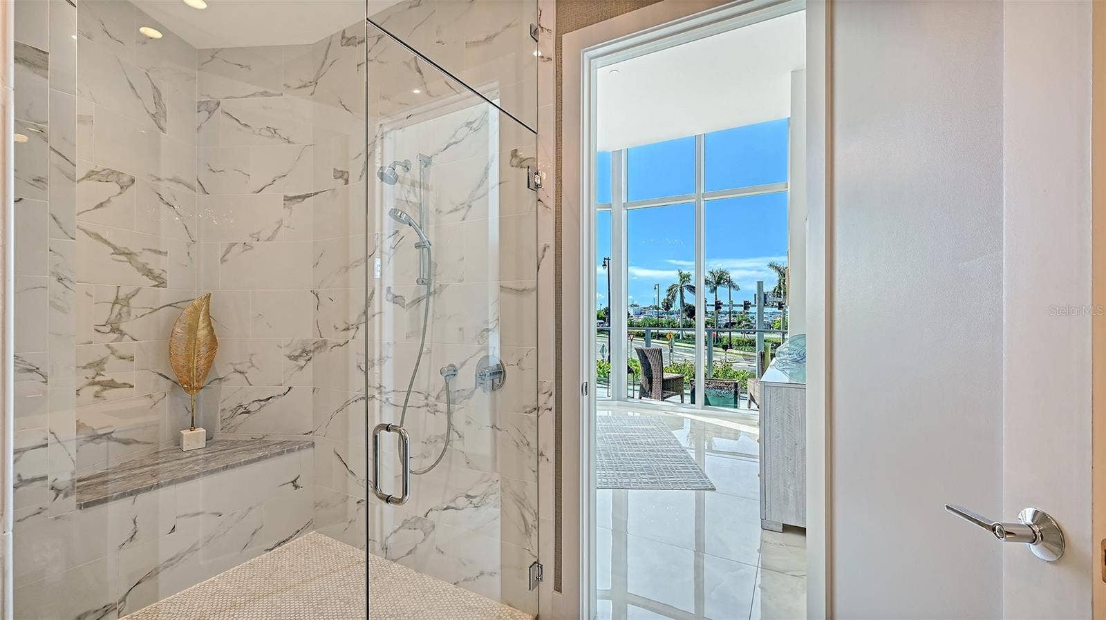1155 N GULFSTREAM AVENUE, #207, Sarasota, FL 34236 A luxurious, oversized walk-in shower enclosed in sleek glass, offering a spa-inspired bathing experience.