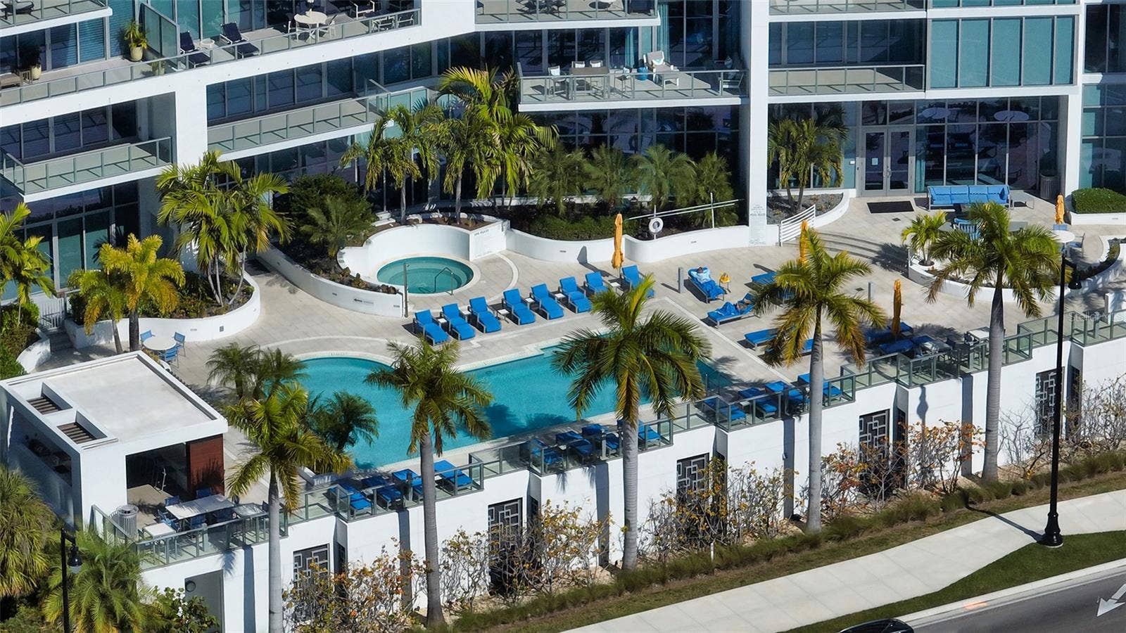 1155 N GULFSTREAM AVENUE, #207, Sarasota, FL 34236 An aerial perspective showcasing The VUEs striking architecture and beautiful resort-style pool, highlighting its exceptional design and luxurious waterfront setting.