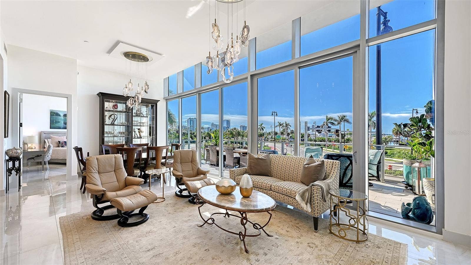 1155 N GULFSTREAM AVENUE, #207, Sarasota, FL 34236 A sun-drenched, open-concept living space that flows seamlessly onto a private 533-square-foot balcony, showcasing spectacular panoramic waterfront views.