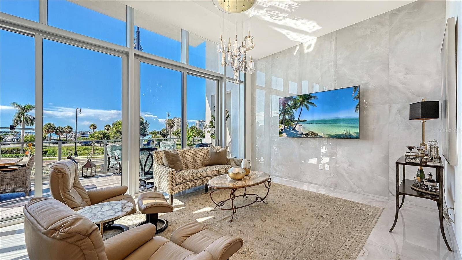 1155 N GULFSTREAM AVENUE, #207, Sarasota, FL 34236 The grand great room showcases over 28 feet of soaring 12-foot floor-to-ceiling windows, capturing breathtaking panoramic views of Sarasota Bay.