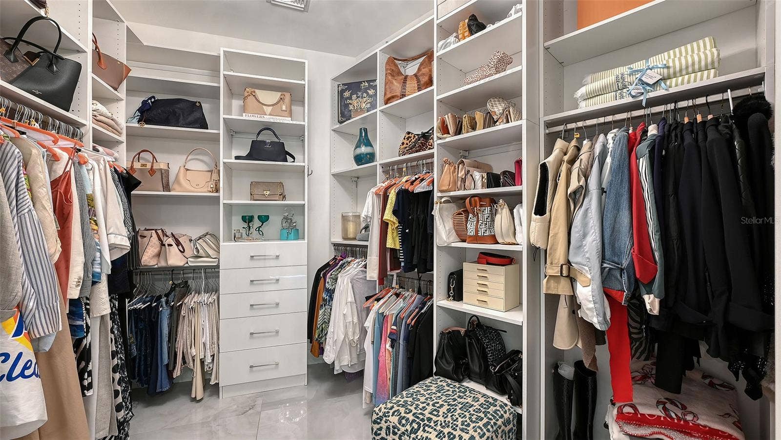 1155 N GULFSTREAM AVENUE, #207, Sarasota, FL 34236 Custom-designed primary closet with elegant display areas and refined, organized storage.