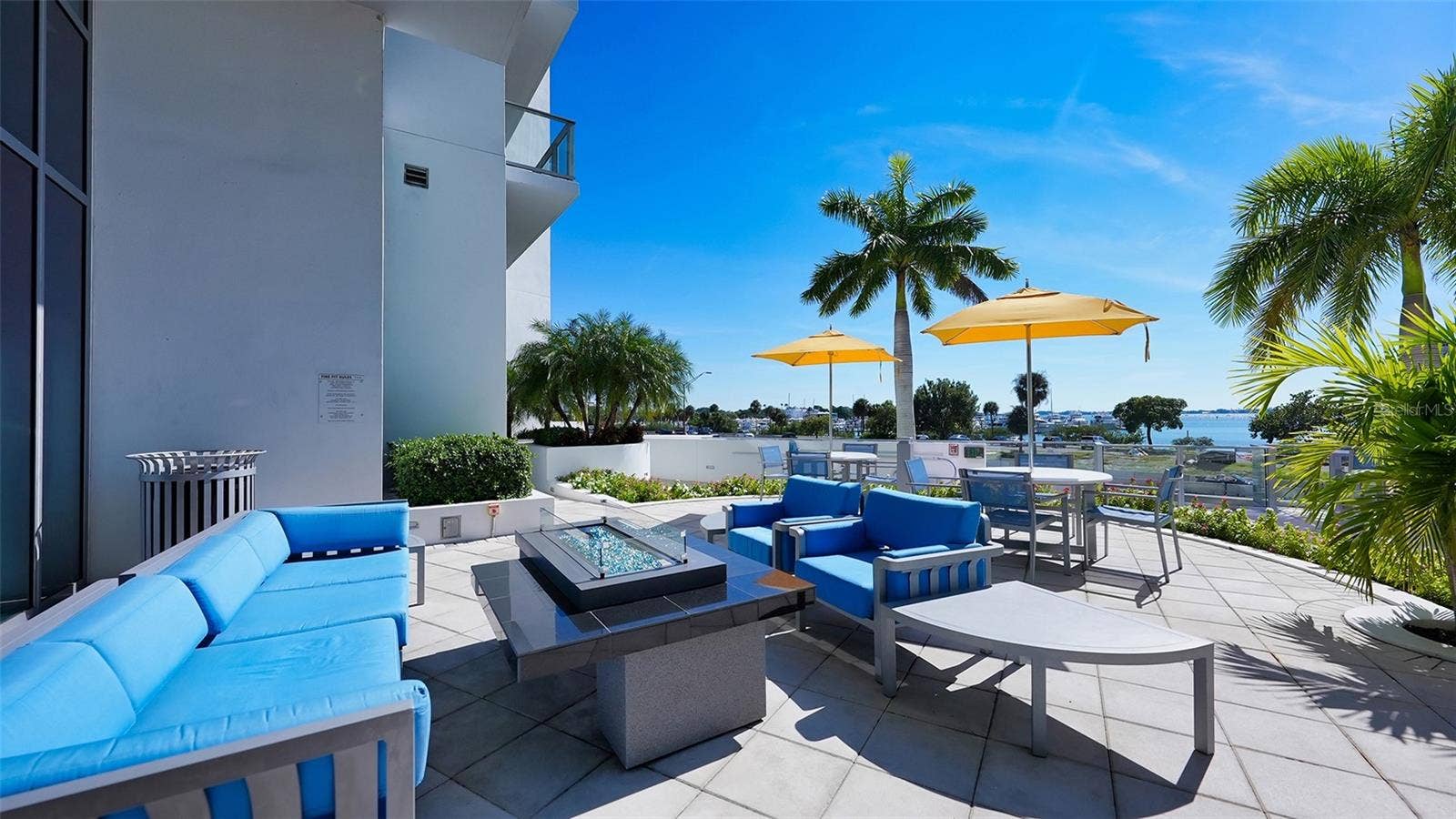 1155 N GULFSTREAM AVENUE, #207, Sarasota, FL 34236 An inviting poolside seating area with a fire pit, perfect for relaxed gatherings, evening conversations, and entertaining under the stars.