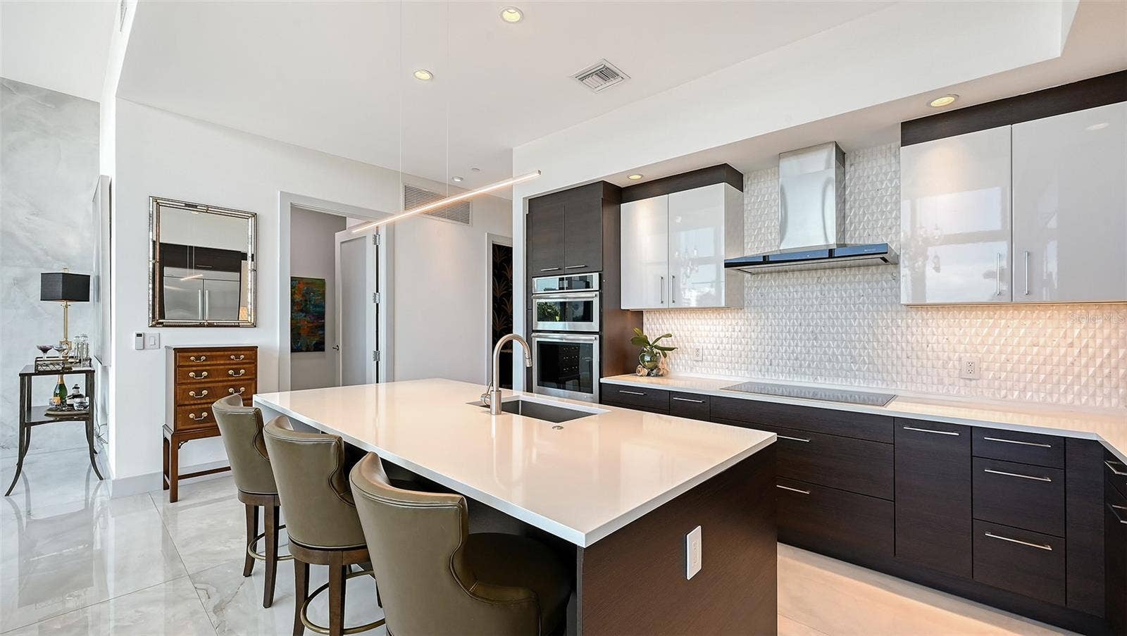 1155 N GULFSTREAM AVENUE, #207, Sarasota, FL 34236 Open-concept kitchen featuring rich dark cabinetry, sleek countertops, and a spacious island with bar seating