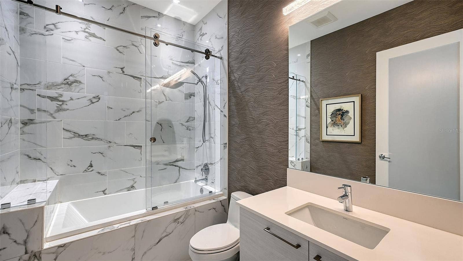 1155 N GULFSTREAM AVENUE, #207, Sarasota, FL 34236 A luxurious, oversized walk-in shower enclosed in sleek glass, offering a spa-inspired bathing experience.