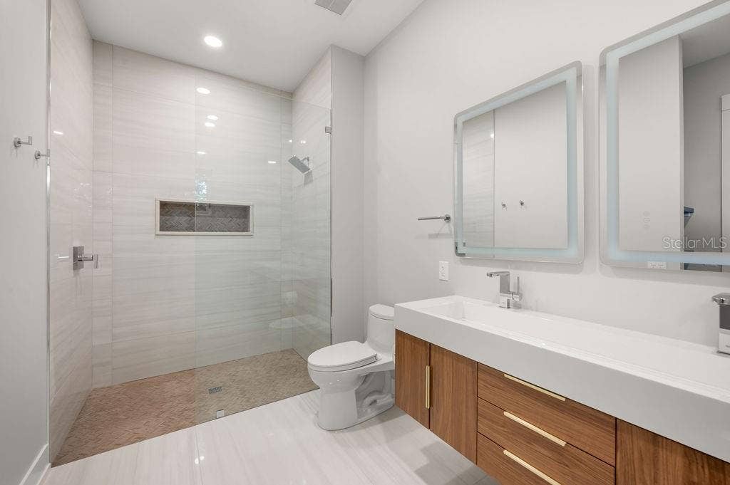3360 BAYOU SOUND, Longboat Key, FL 34228 Beautifully designed guest bath featuring custom tile work and sophisticated finishes.