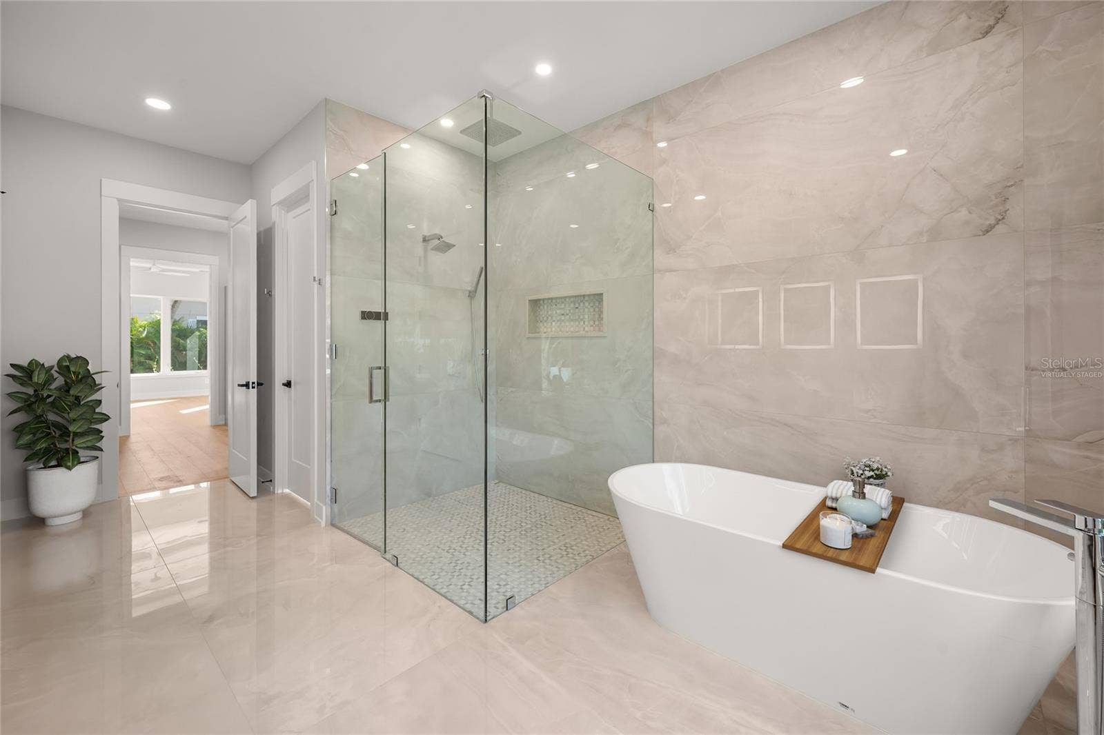 3360 BAYOU SOUND, Longboat Key, FL 34228 Virtually staged primary suite features a luxurious spa-inspired bath with soaking tub, spacious walk-in shower, designer tile, beautifully curated finishes, and a generous walk-in closet.