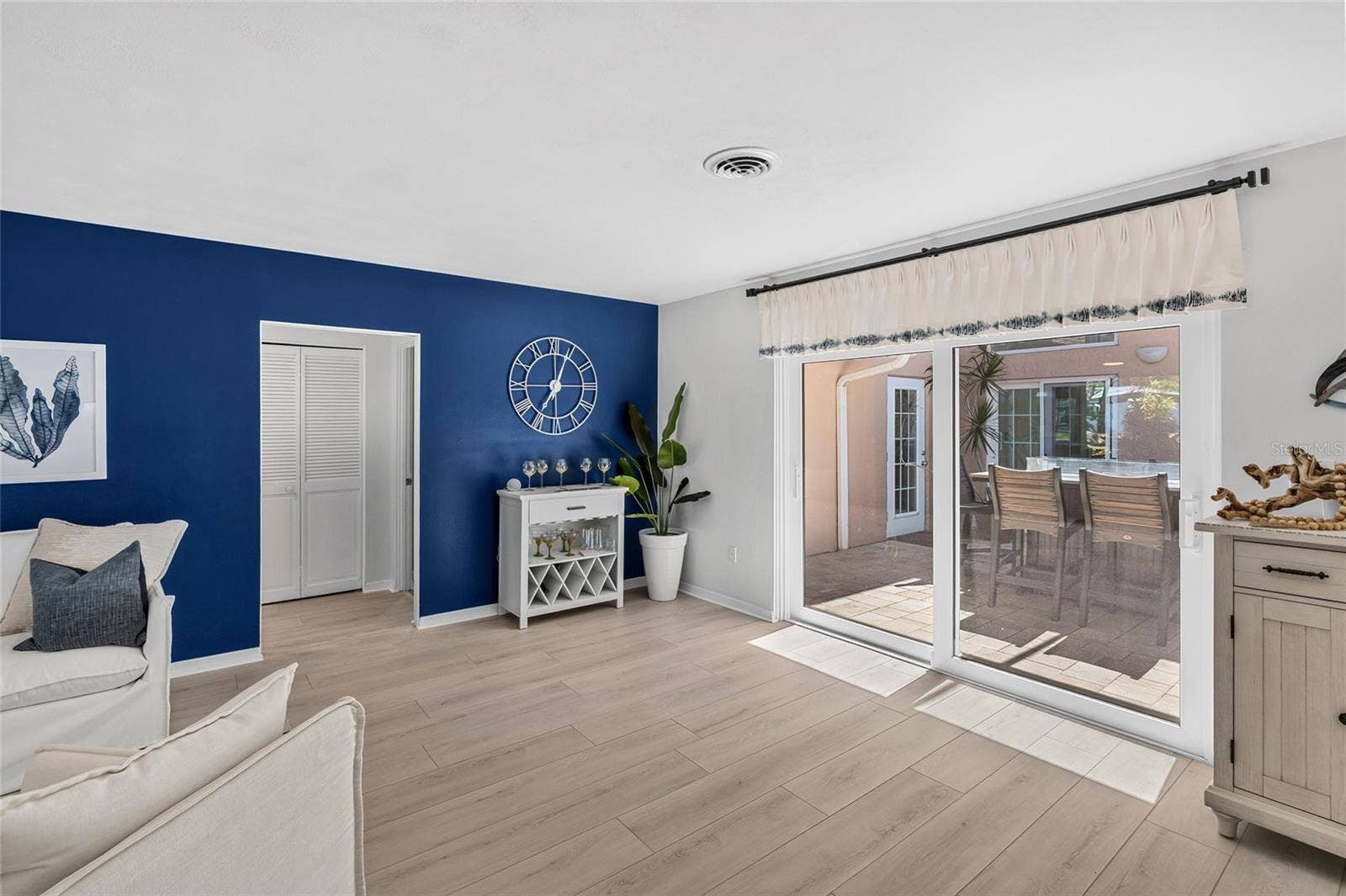 Living area opens directly to the screened courtyard lanai with tabletop fire pit and access toward the pool.