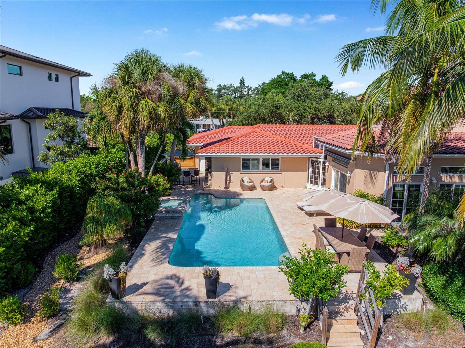 Elevated daytime view captures the pool, patio and generous rear outdoor spaces.