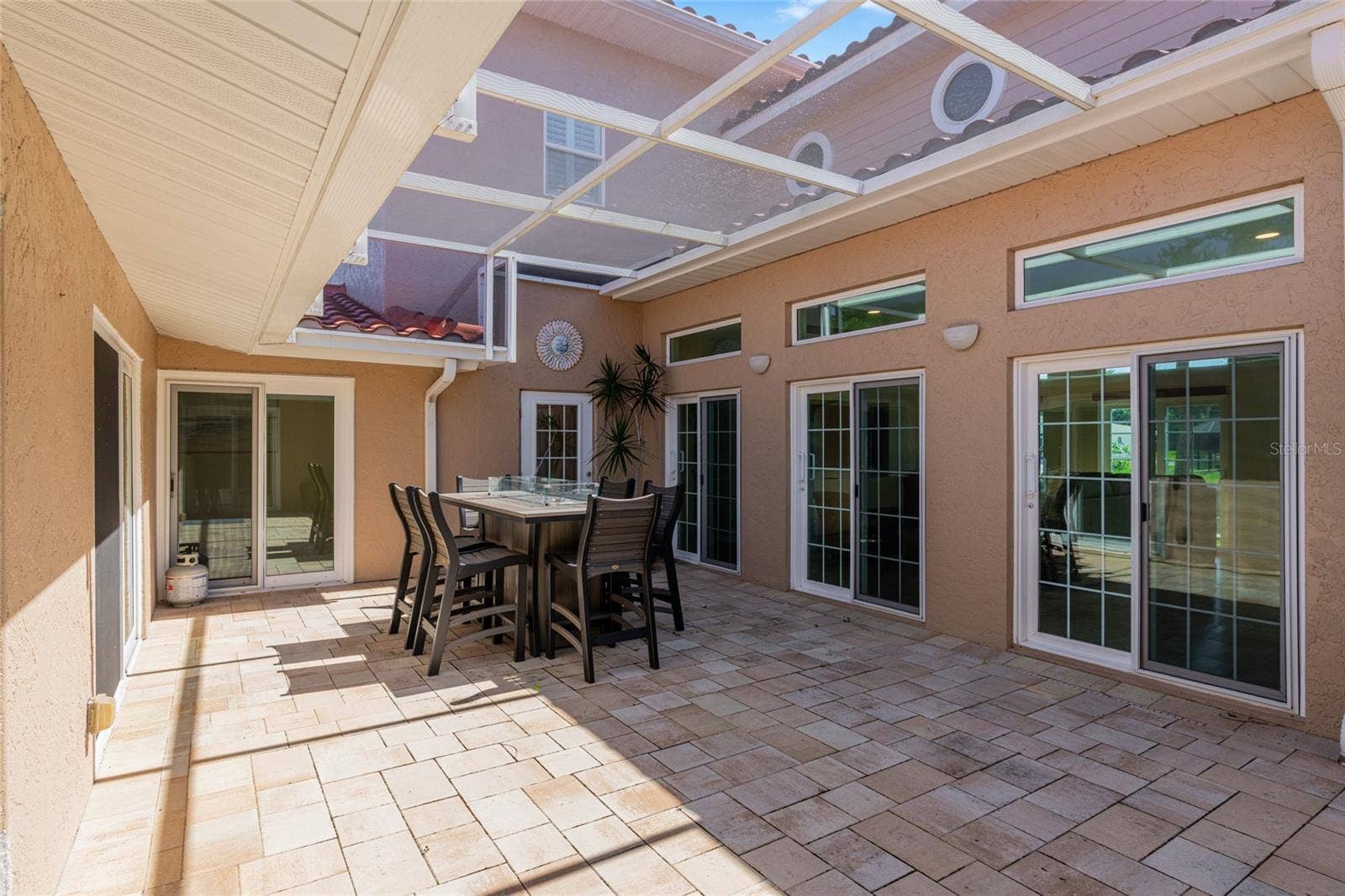 Daytime view of the fully screened courtyard lanai at the center of the home, connecting multiple living spaces with the route toward the pool.