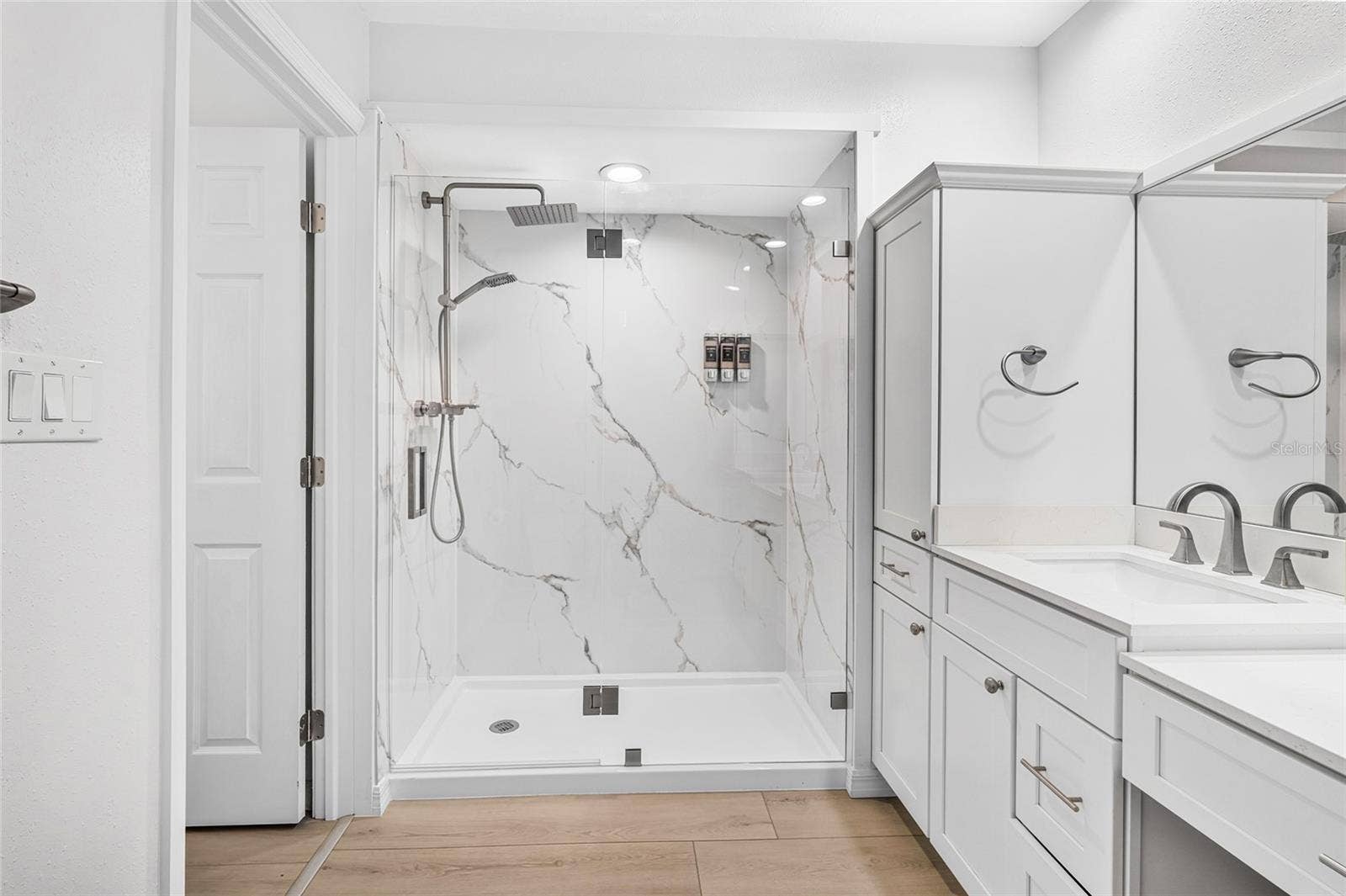 The renovated 2026 first floor primary bath features an oversized shower and upscale finishes.