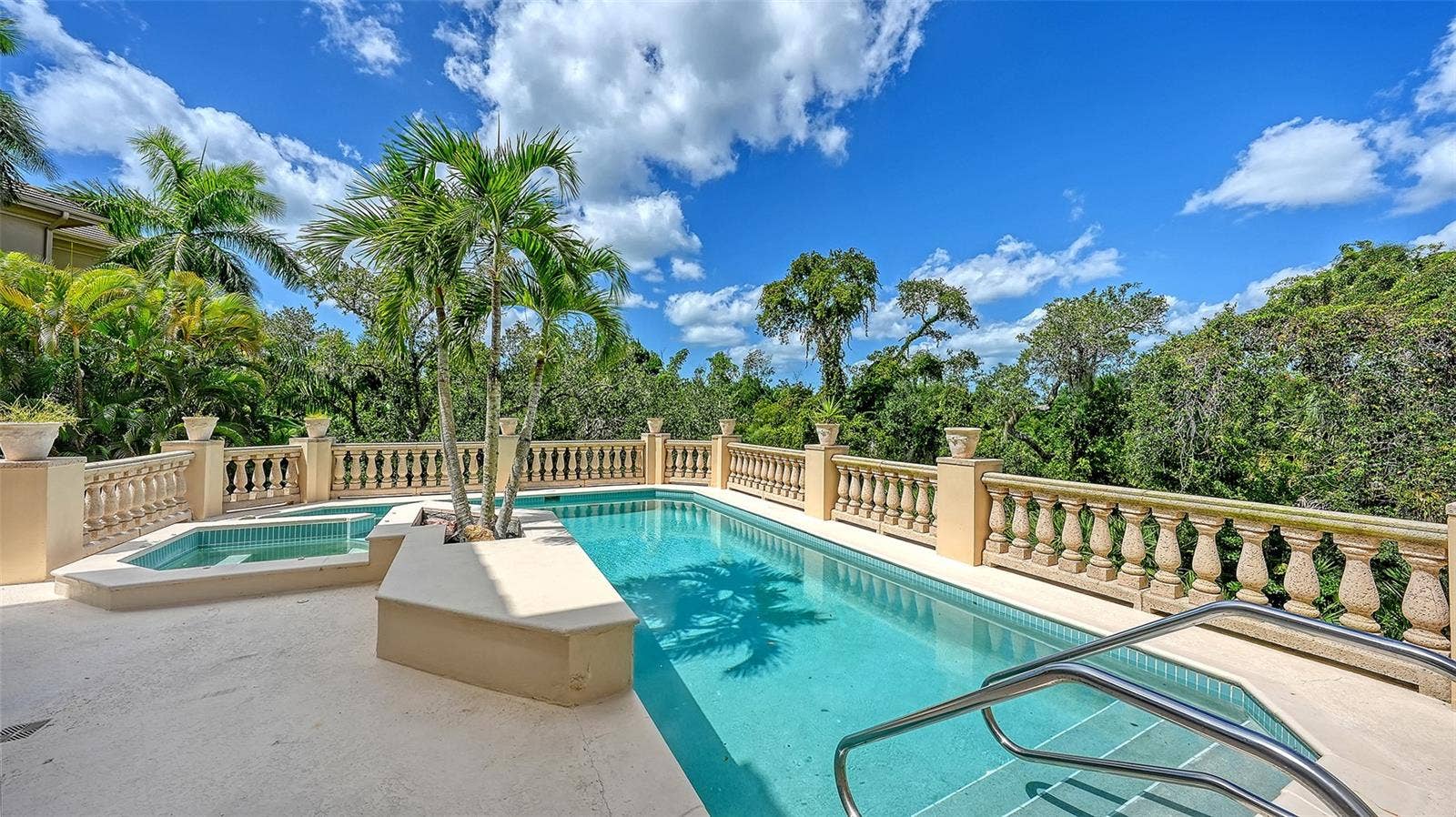 168 COASTAL HAMMOCK COURT, Osprey, FL 34229 The elevated pool terrace is surrounded by tropical greenery, creating an intimate outdoor retreat.