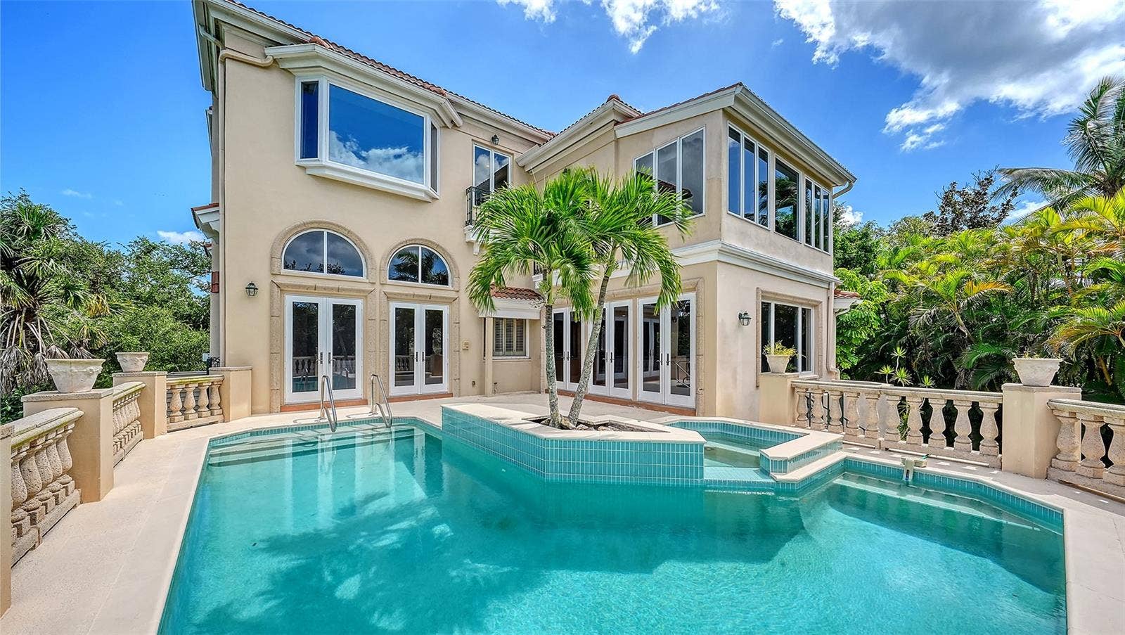 168 COASTAL HAMMOCK COURT, Osprey, FL 34229 French doors open directly to the pool terrace, seamlessly connecting the home with its private outdoor setting.