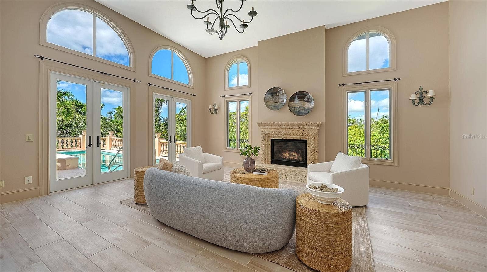 168 COASTAL HAMMOCK COURT, Osprey, FL 34229 Walls of windows and French doors fill the great room with natural light while connecting the interior to the surrounding landscape.